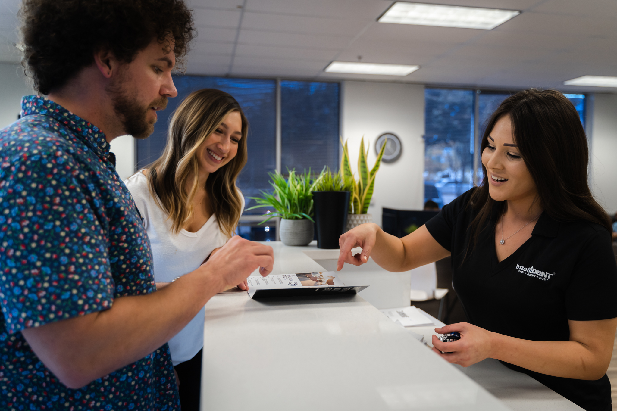 IntelliDent customers looking at dent repair pamphlet